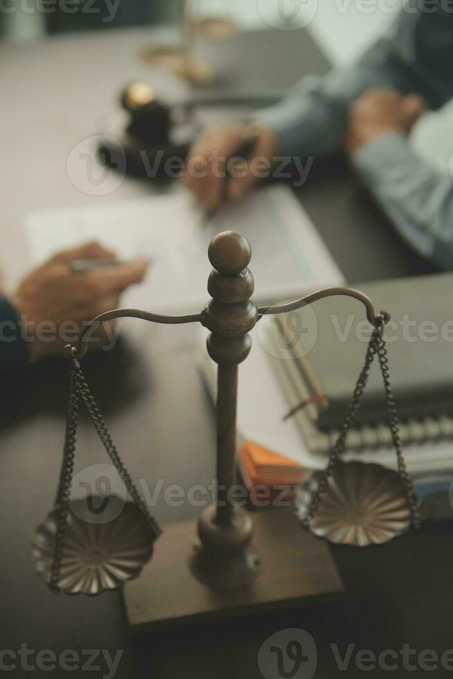 Business and lawyers discussing contract papers with brass scale on desk in office. Law, legal services, advice, justice and law concept picture with film grain effect photo