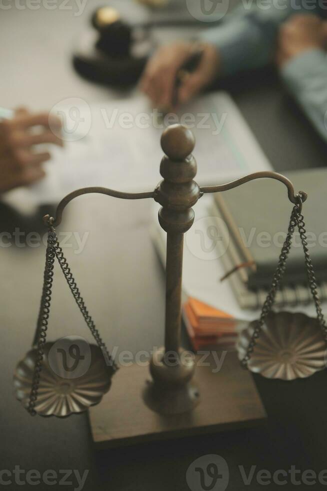 Business and lawyers discussing contract papers with brass scale on desk in office. Law, legal services, advice, justice and law concept picture with film grain effect photo