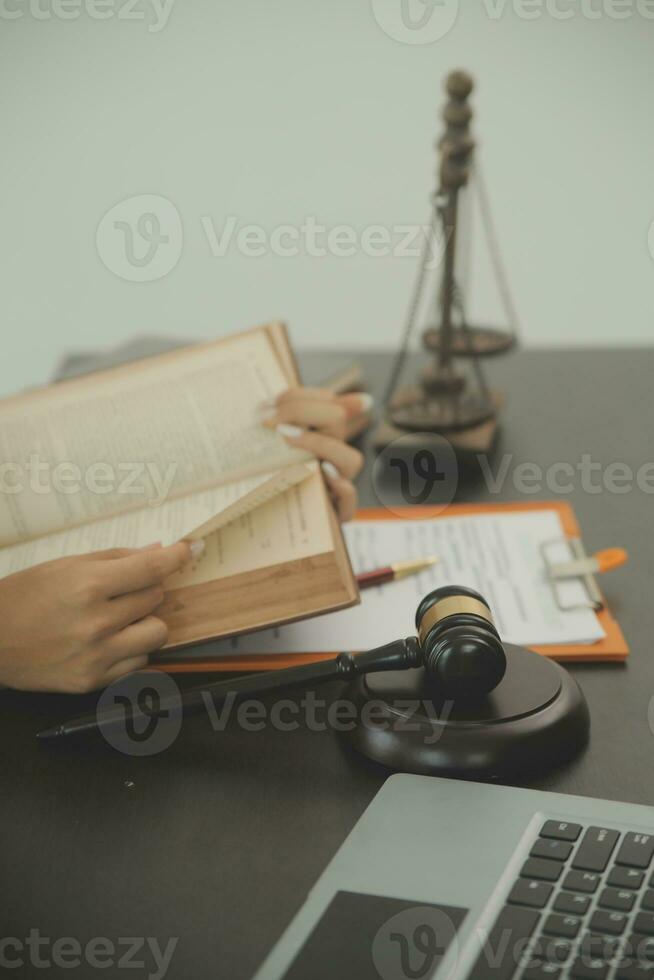Justice and law concept.Male judge in a courtroom with the gavel, working with, computer and docking keyboard, eyeglasses, on table in morning light photo