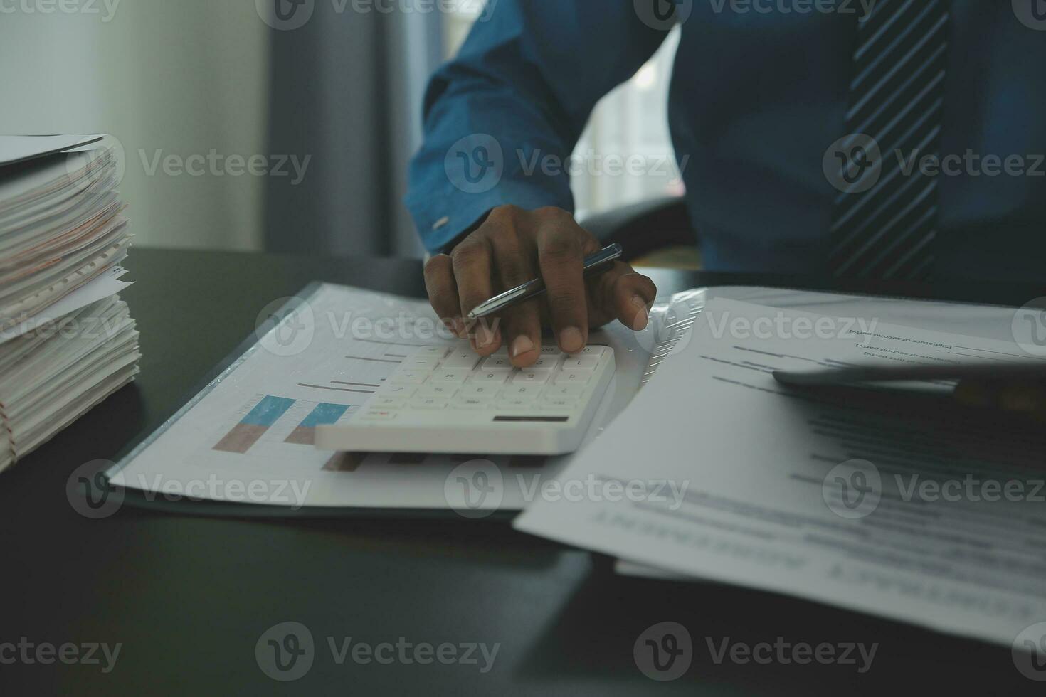 Man signing car insurance document or lease paper. Writing signature on contract or agreement. Buying or selling new or used vehicle. Car keys on table. Warranty or guarantee. Customer or salesman. photo