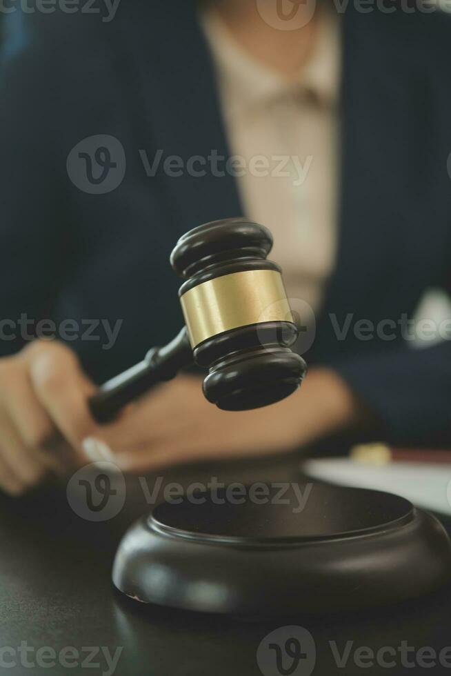 Justice and law concept.Male judge in a courtroom with the gavel, working with, computer and docking keyboard, eyeglasses, on table in morning light photo