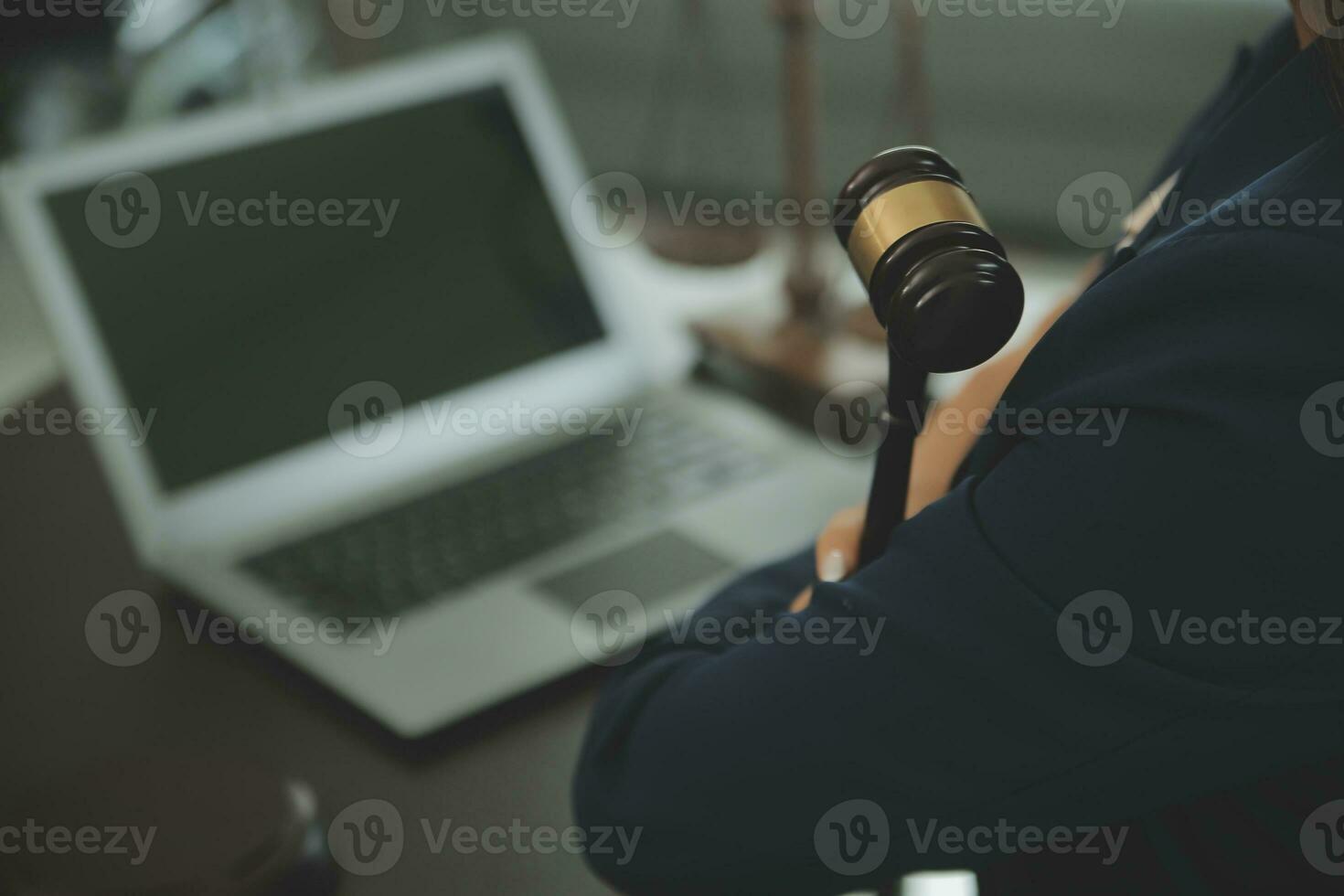 Justice and law concept.Male judge in a courtroom with the gavel, working with, computer and docking keyboard, eyeglasses, on table in morning light photo