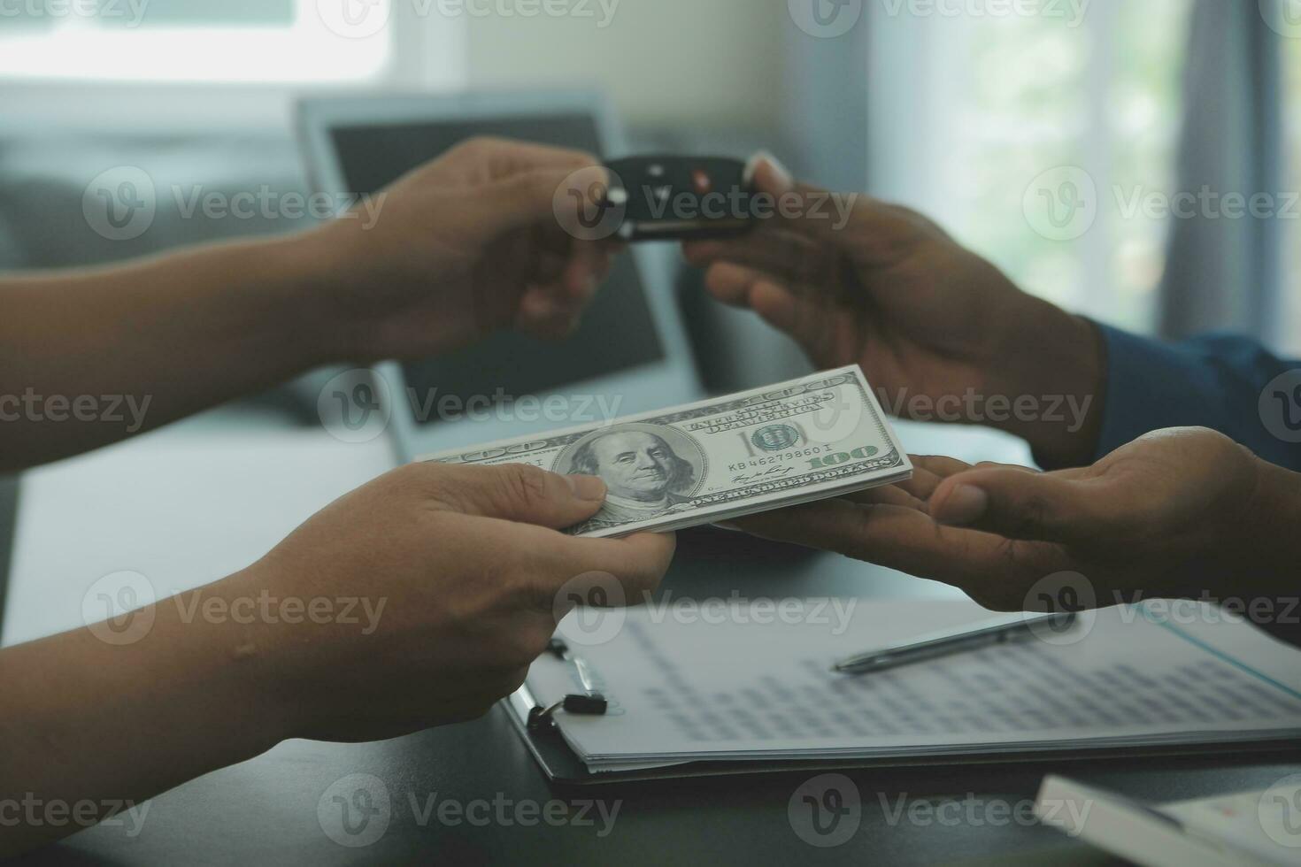 Man signing car insurance document or lease paper. Writing signature on contract or agreement. Buying or selling new or used vehicle. Car keys on table. Warranty or guarantee. Customer or salesman. photo