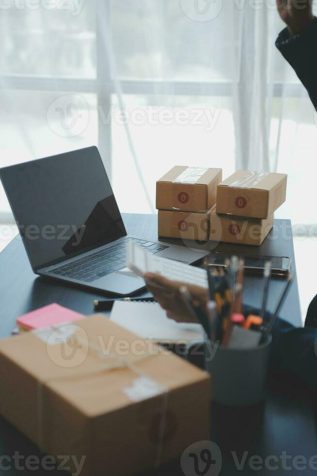 Business woman start up small business entrepreneur SME success .freelance woman working at home with Online Parcel delivery. SME and packaging deliveryconcept photo