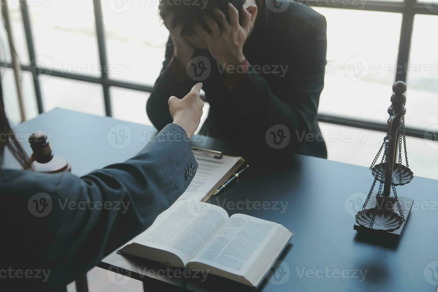 Justice and law concept.Male judge in a courtroom with the gavel, working with, computer and docking keyboard, eyeglasses, on table in morning light photo