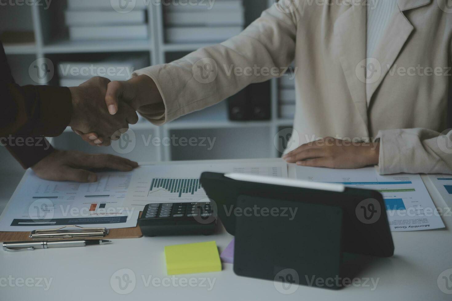 Asian Business woman using calculator and laptop for doing math finance on an office desk, tax, report, accounting, statistics, and analytical research concept photo