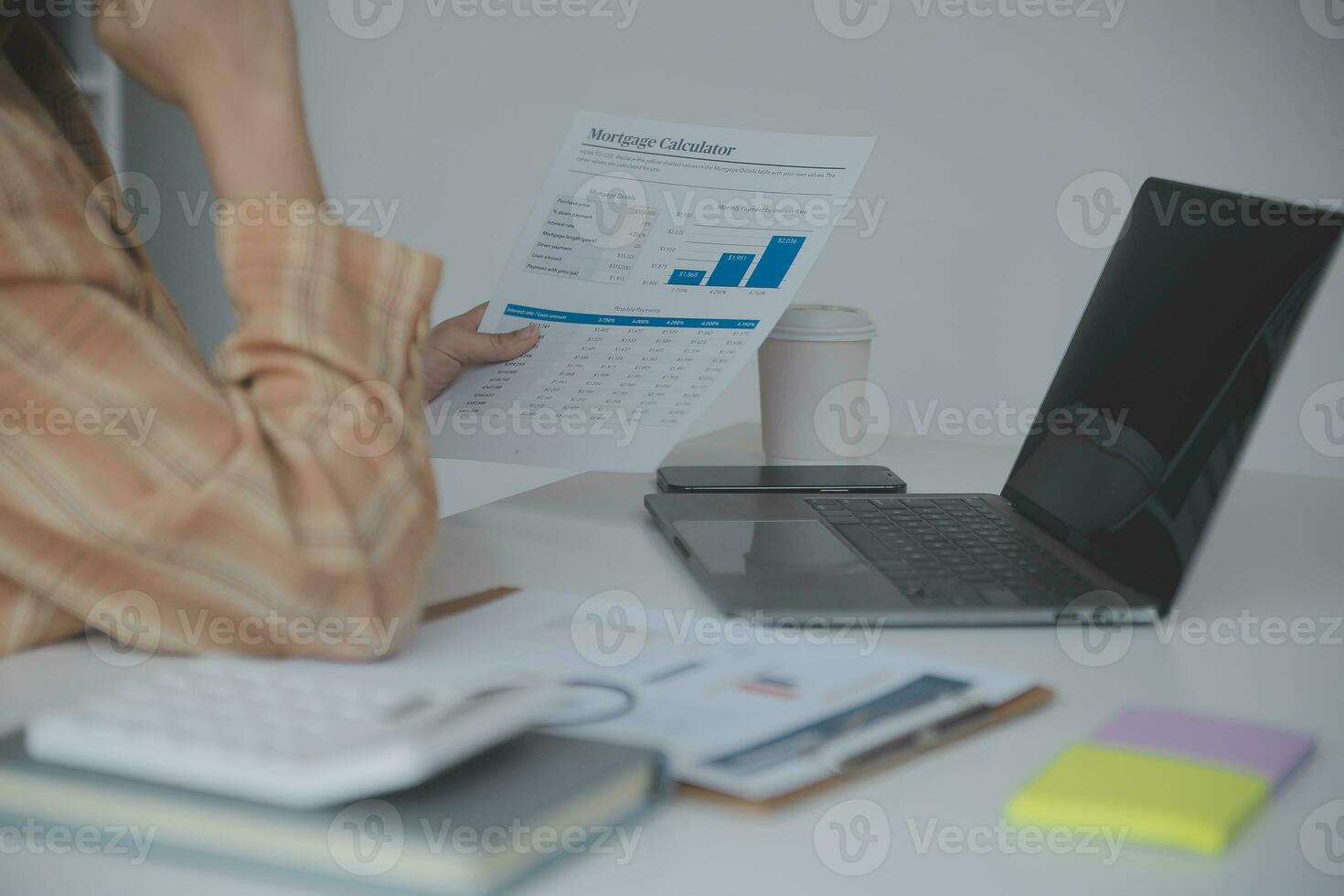 Asian Business woman using calculator and laptop for doing math finance on an office desk, tax, report, accounting, statistics, and analytical research concept photo