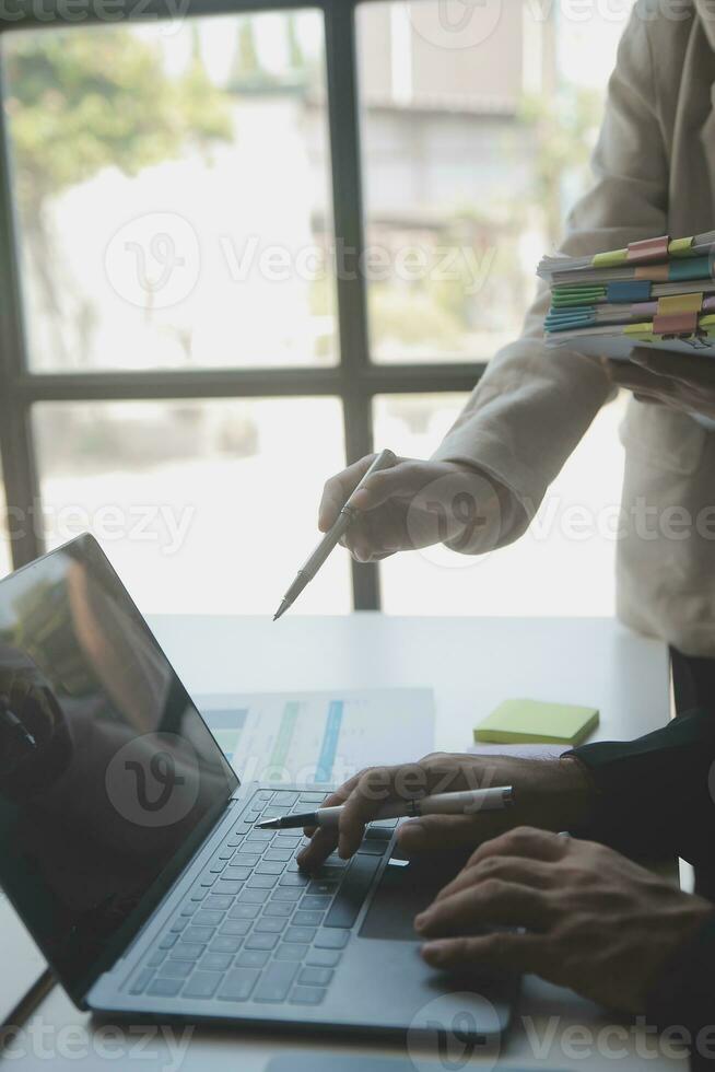 Asian Business woman using calculator and laptop for doing math finance on an office desk, tax, report, accounting, statistics, and analytical research concept photo