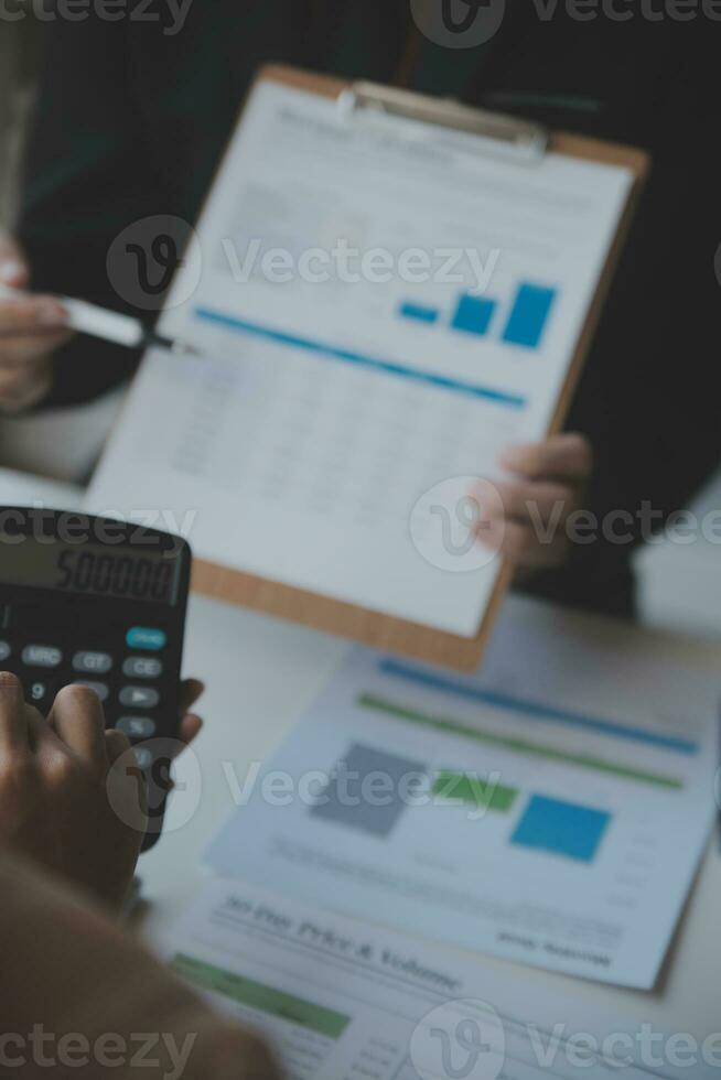 Asian Business woman using calculator and laptop for doing math finance on an office desk, tax, report, accounting, statistics, and analytical research concept photo