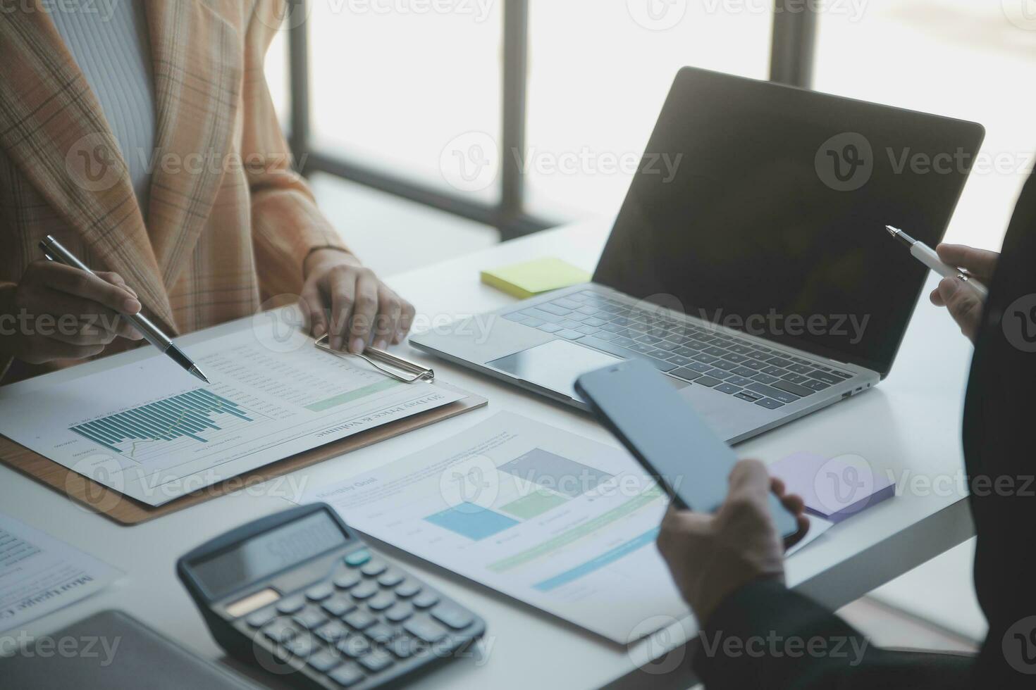 Asian Business woman using calculator and laptop for doing math finance on an office desk, tax, report, accounting, statistics, and analytical research concept photo