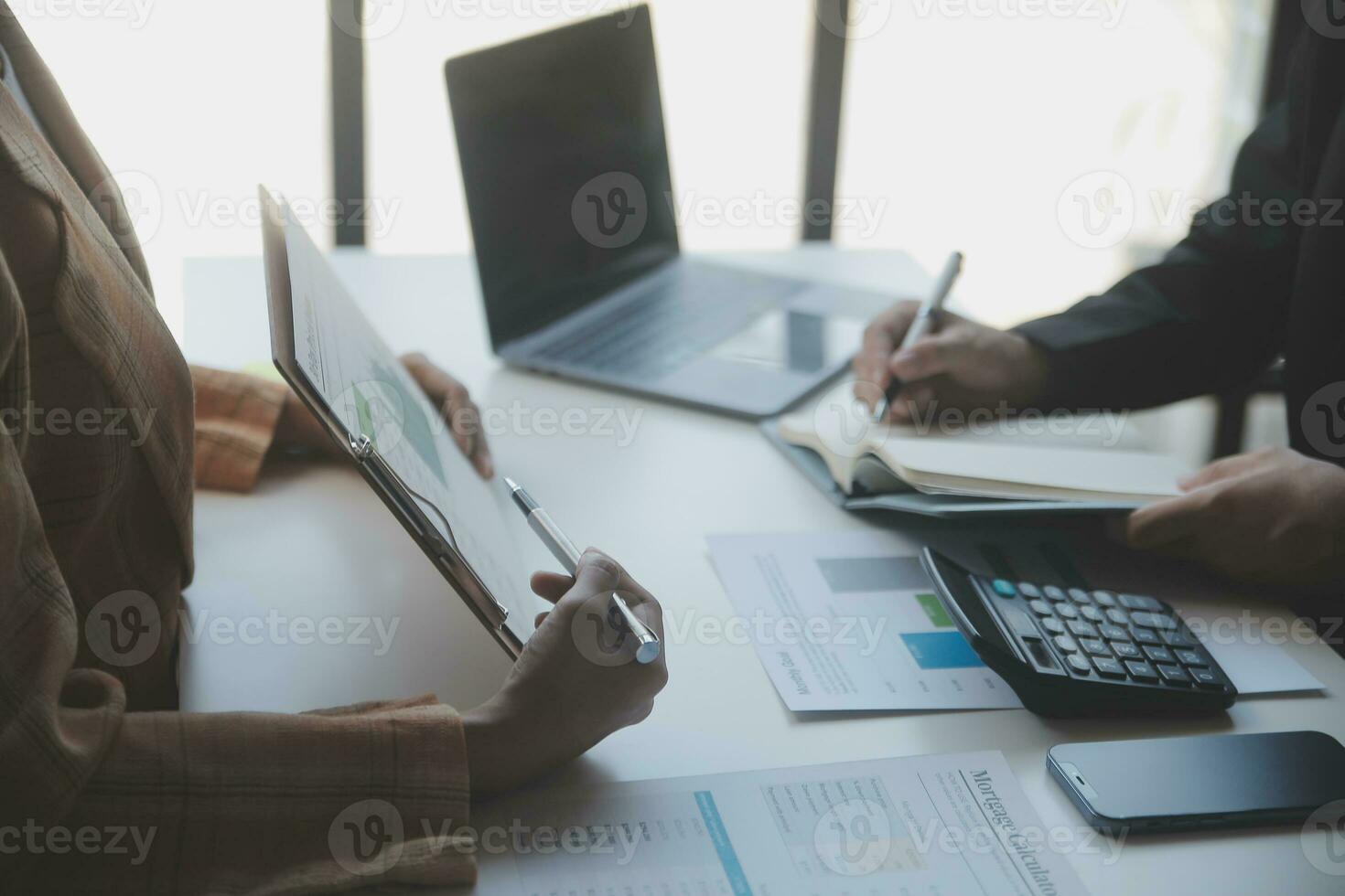 Asian Business woman using calculator and laptop for doing math finance on an office desk, tax, report, accounting, statistics, and analytical research concept photo