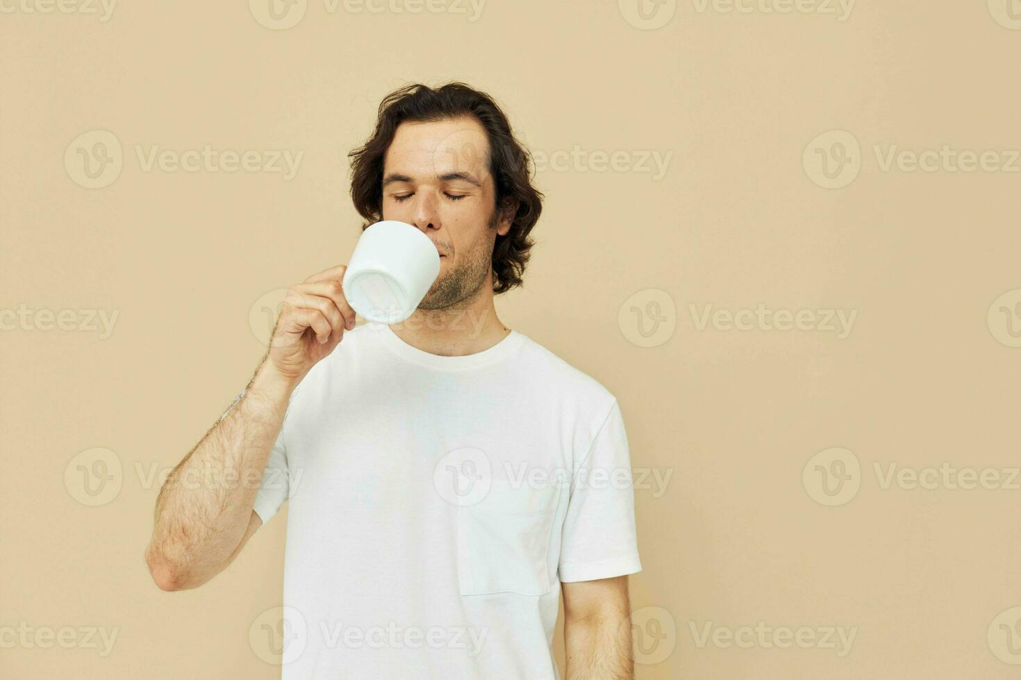 handsome man with a white mug in his hands emotions posing isolated background photo