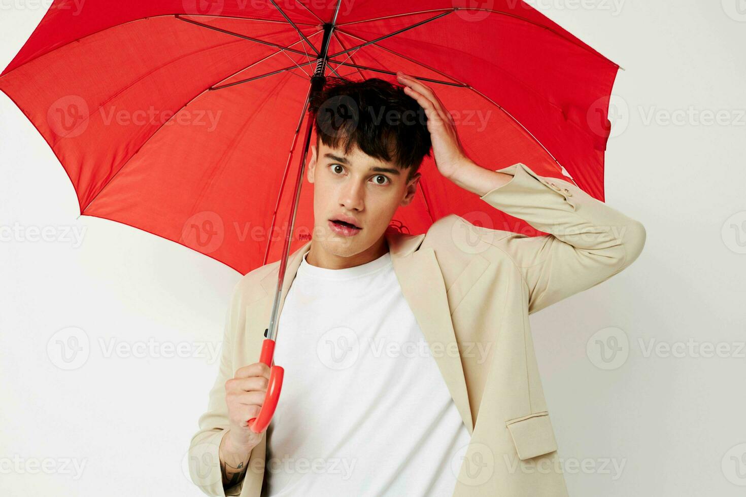portrait of a young man holding an umbrella in the hands of posing fashion light background unaltered photo