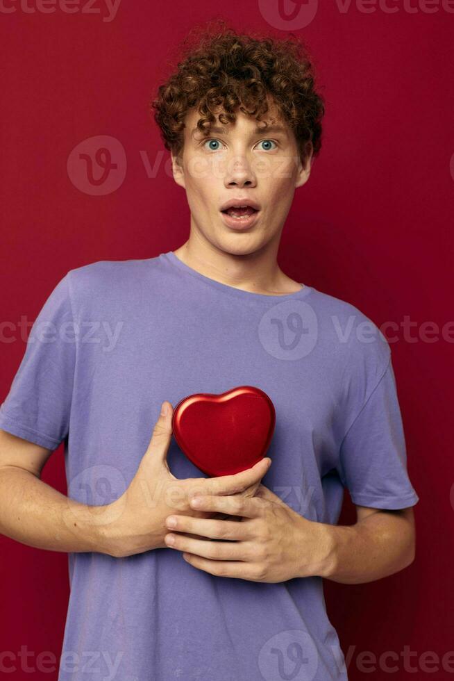 young man heart shaped gift red background photo