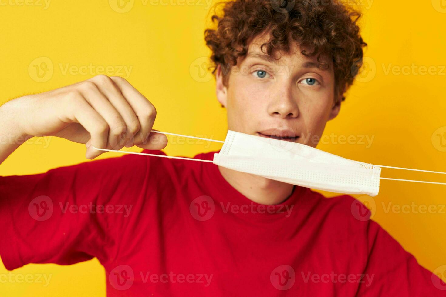 guy with red curly hair wearing a red t-shirt medical mask on the face posing Lifestyle unaltered photo