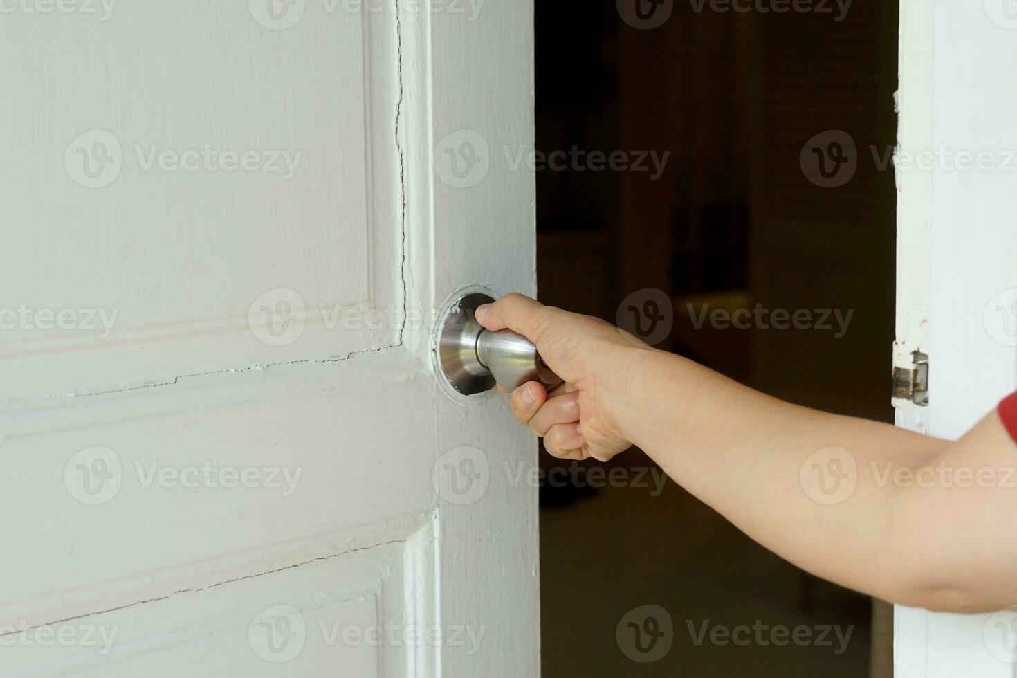 turistas giro el Perilla de la puerta de un blanco de madera puerta a entrar un hotel habitación. suave y selectivo enfocar. foto