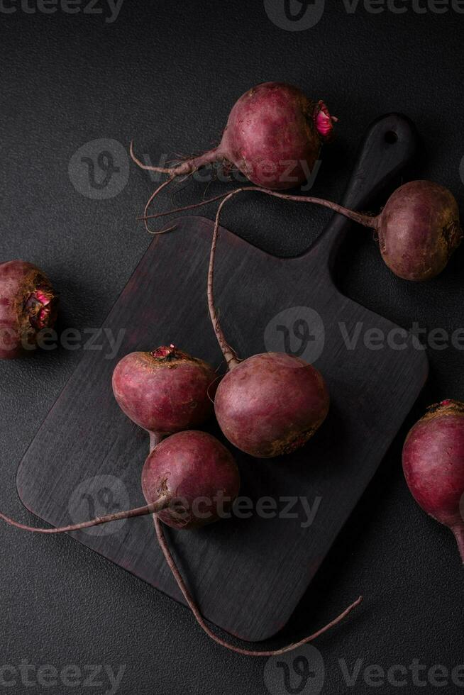 Fresh raw beetroot in the form of tubers on a textured concrete background photo