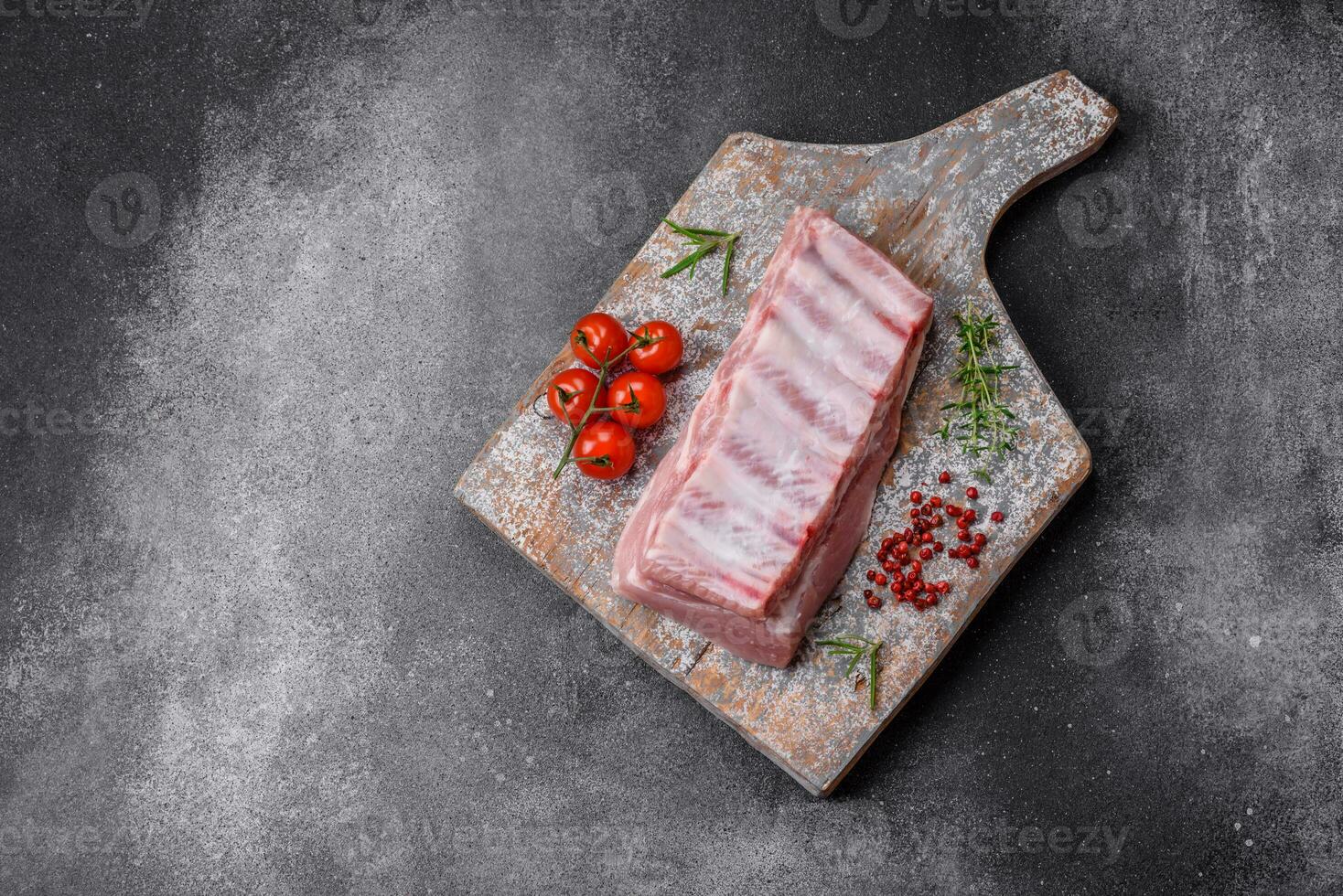 Raw pork ribs with meat with salt, spices and herbs photo