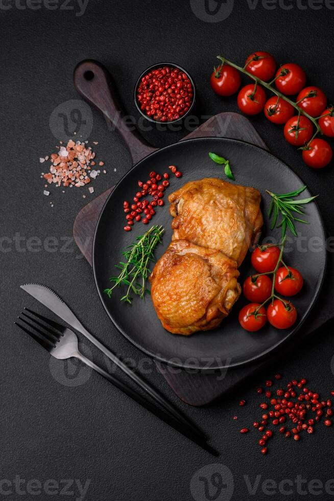 delicioso jugoso pollo muslos horneado con sal, especias y hierbas en un cerámico plato foto