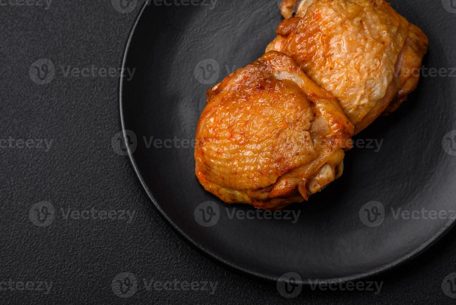 Delicious juicy chicken thighs baked with salt, spices and herbs in a ceramic plate photo