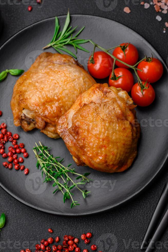 Delicious juicy chicken thighs baked with salt, spices and herbs in a ceramic plate photo