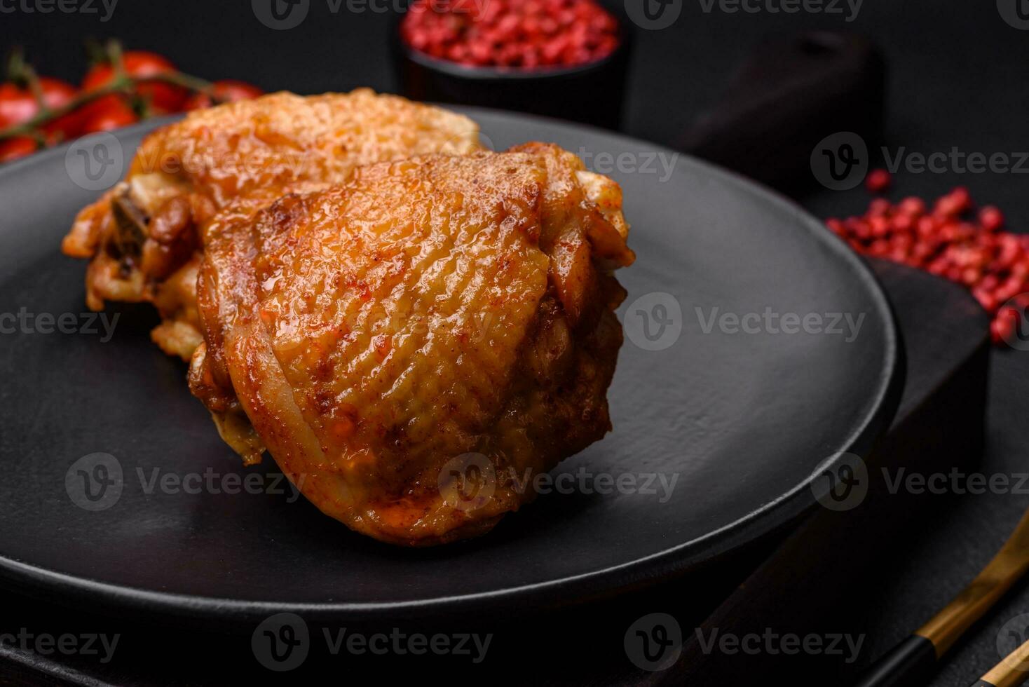 Delicious juicy chicken thighs baked with salt, spices and herbs in a ceramic plate photo