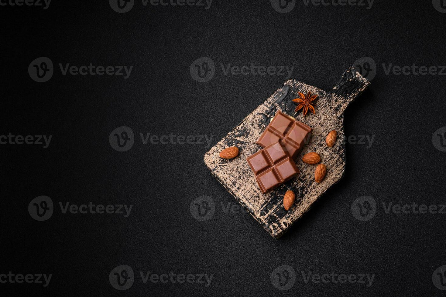 Delicious sweet milk chocolate broken into cubes on a wooden cutting board photo