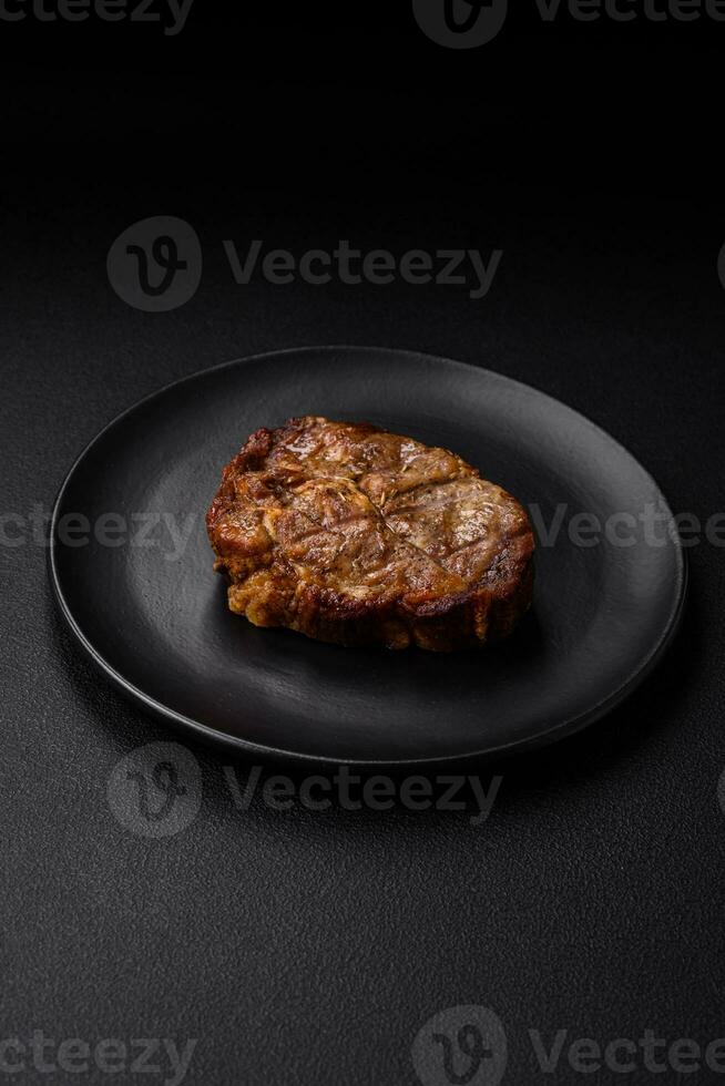 Delicious juicy pork or beef steak grilled with salt, spices and herbs photo