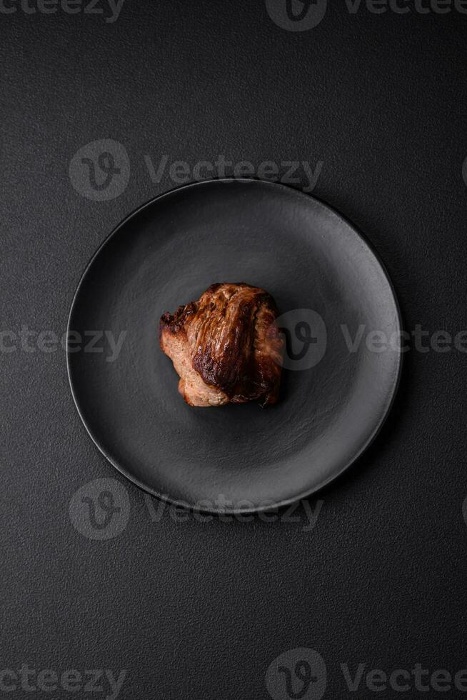 Delicious beef steak with salt, spices and herbs on a ceramic plate photo