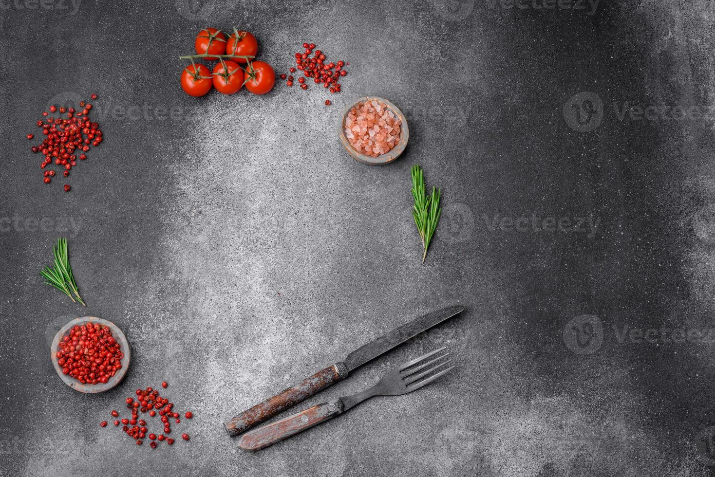 Ingredients, spices, salt, tomatoes, rosemary and cutlery knife and fork photo