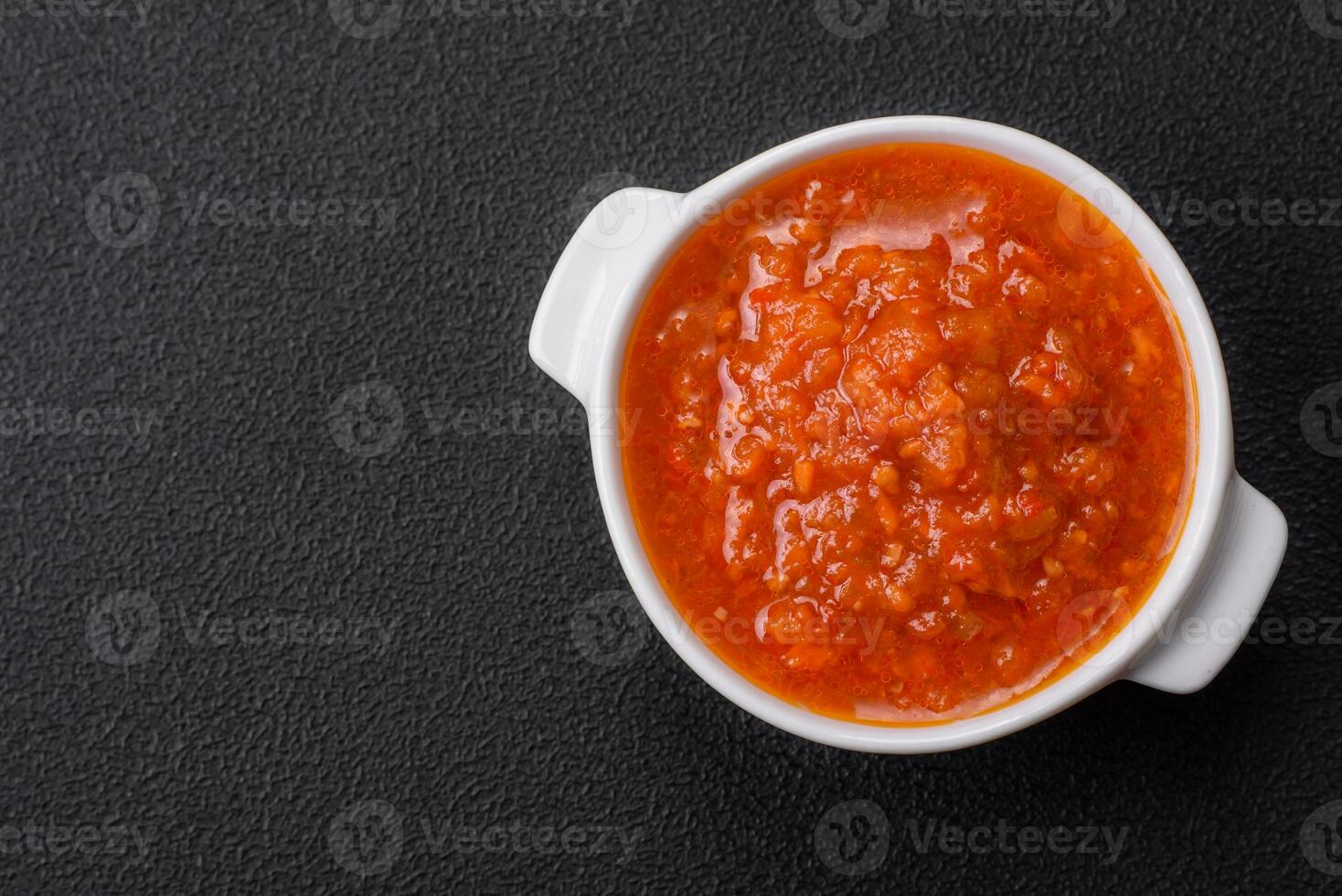 delicioso picante tomate salsa con pimienta, ajo, sal, especias y hierbas foto