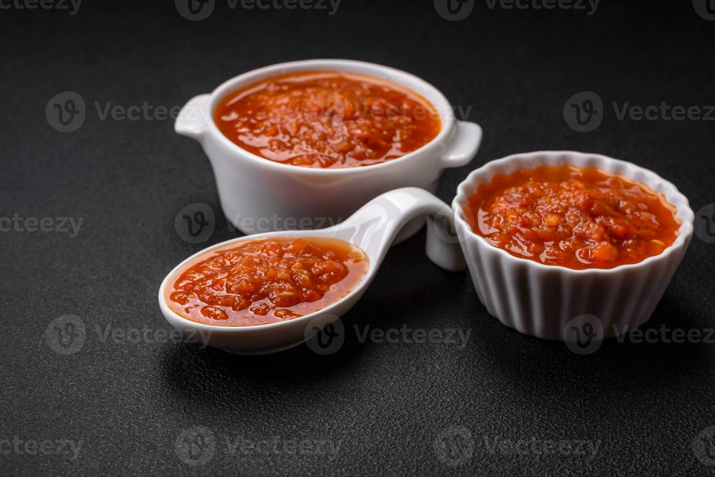 delicioso picante tomate salsa con pimienta, ajo, sal, especias y hierbas foto