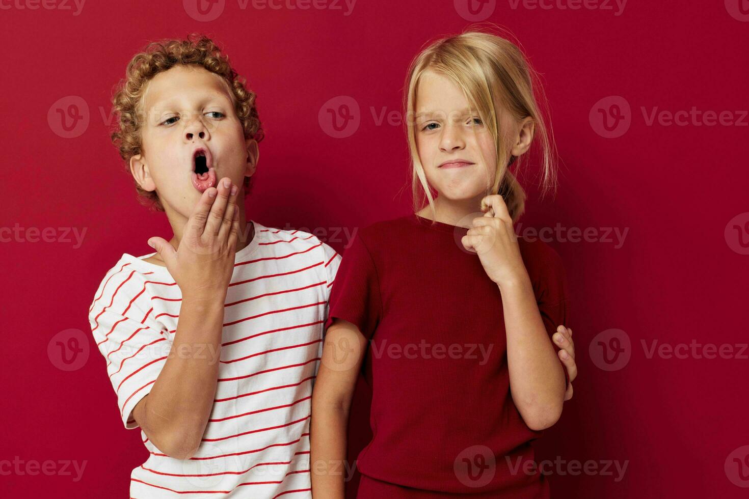 Boy and girl smiling and posing in casual clothes against on colored background photo