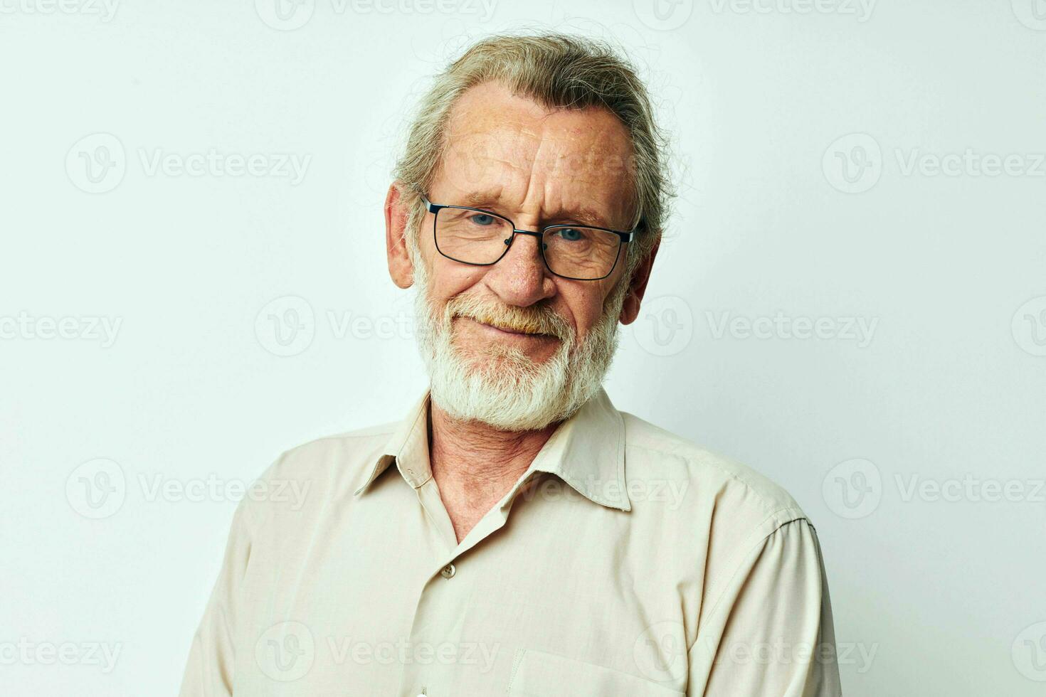 Senior grey-haired man with a gray beard in a shirt and glasses light background photo