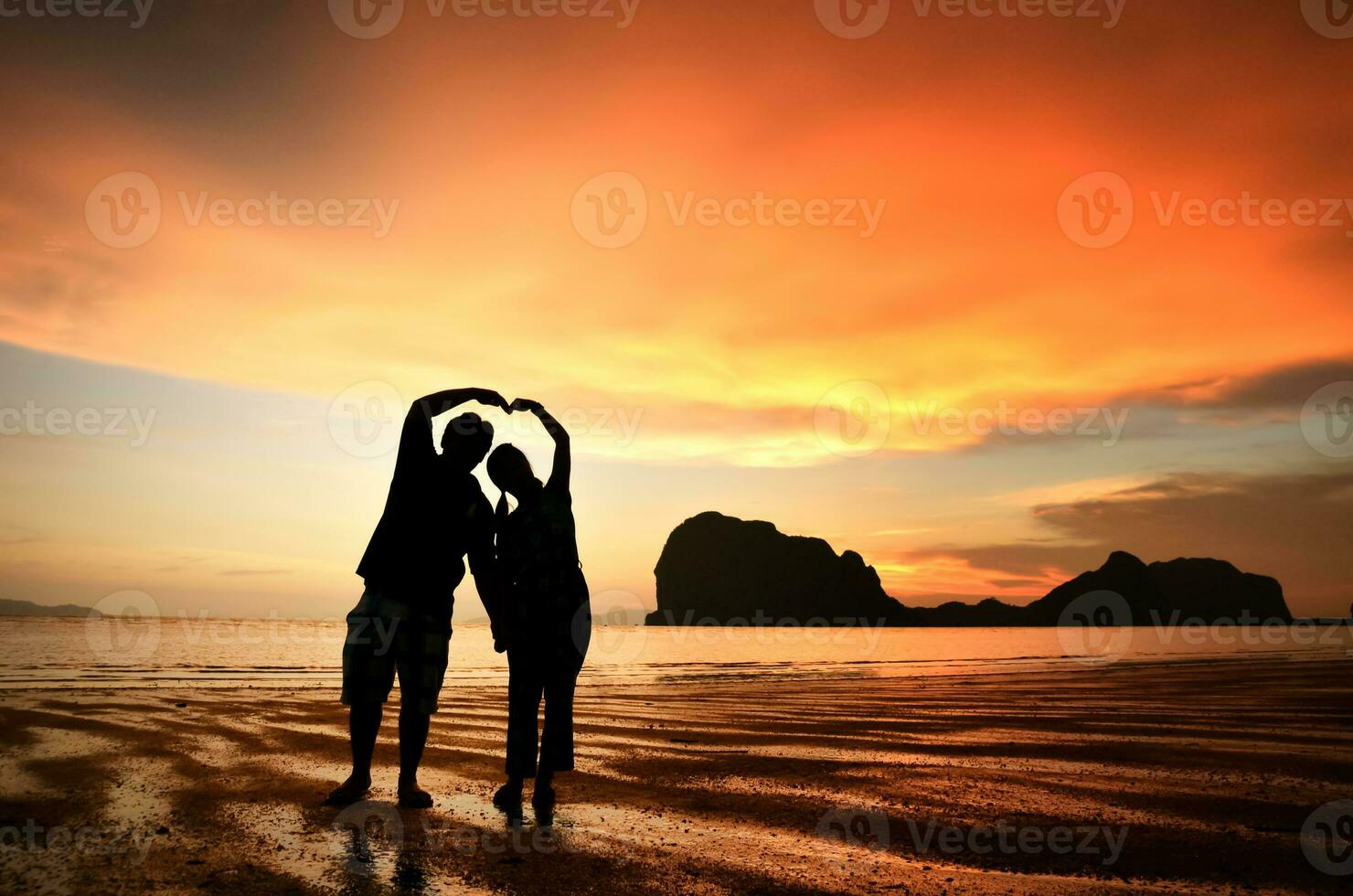 Romantic couple holding hands at sunset on beach photo