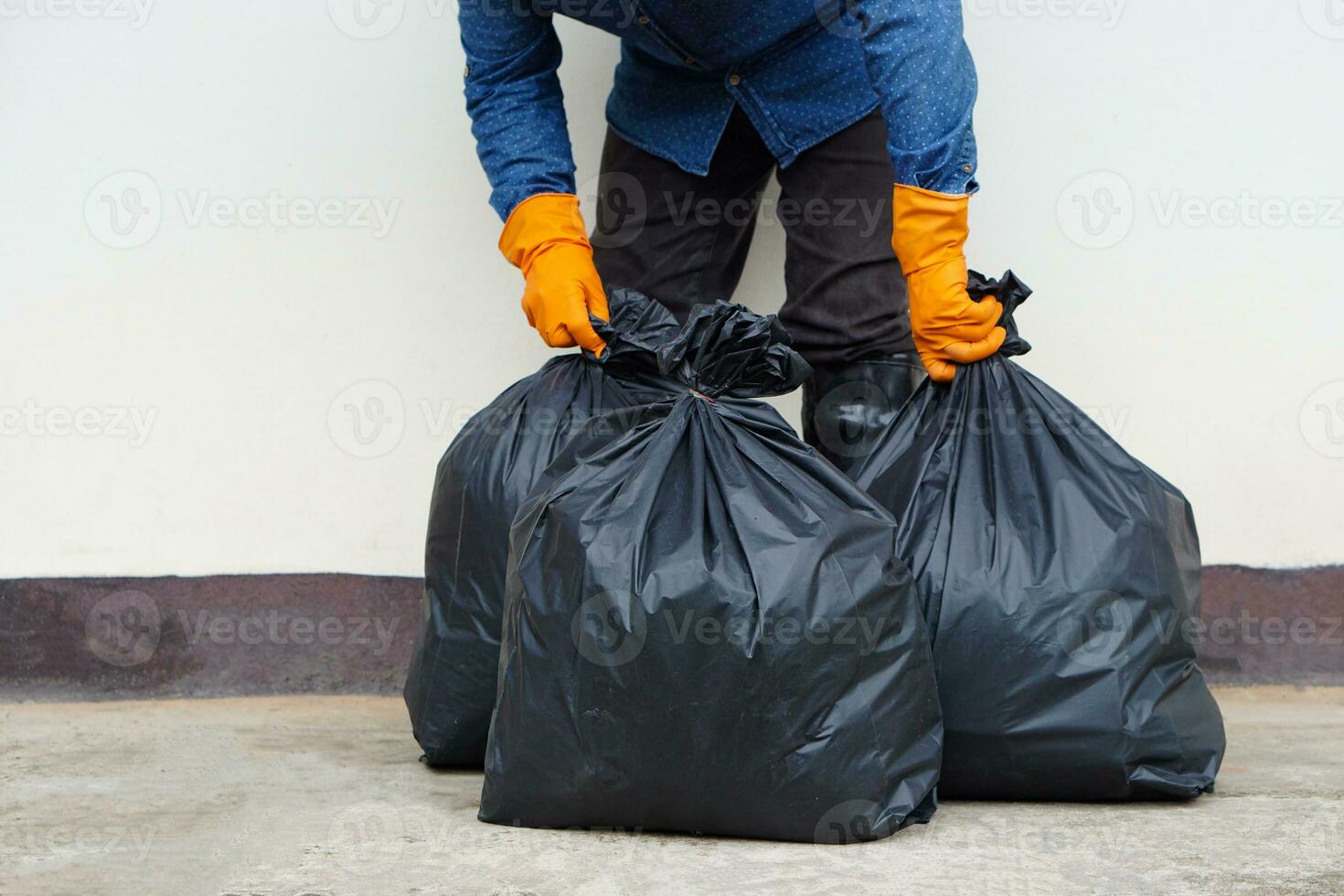 Closeup man holds black plastic bag that contains garbage inside. Concept , Waste management. Environment problems. Daily chores. Throw away rubbish . Sorting type of garbage. photo