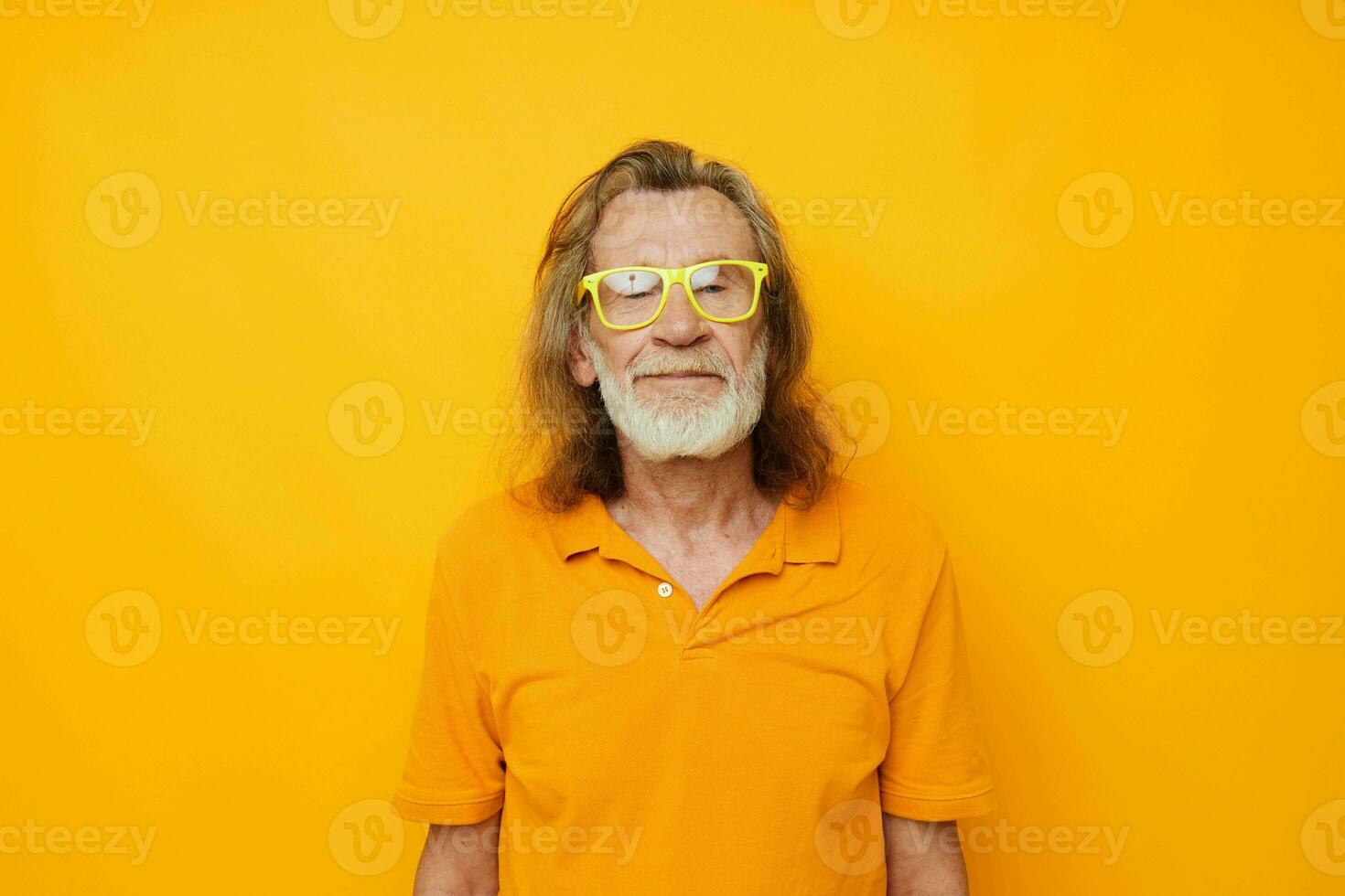 elderly man in yellow glasses with a gray beard emotions yellow background photo