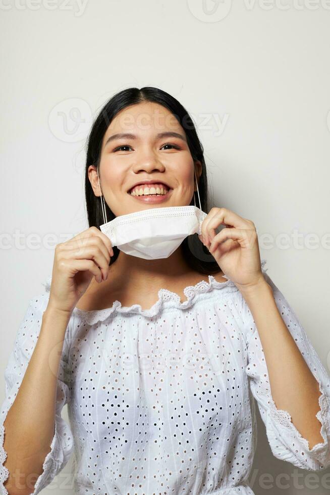 mujer con asiático apariencia médico máscara en el cabeza proteccion estudio modelo inalterado foto