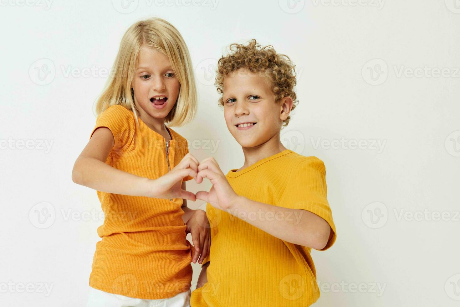 Cheerful Boy and Girl in Yellow T-shirts Posing Studio photo