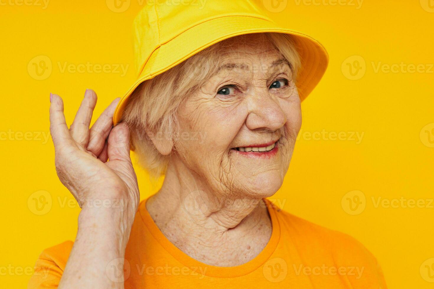 Photo of retired old lady in casual t-shirt yellow panama close-up emotions