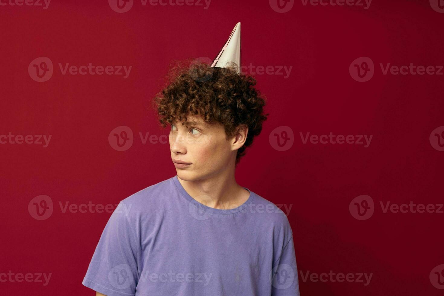 with a cap on his head kinky guy fashion posing hand gestures red background unaltered photo