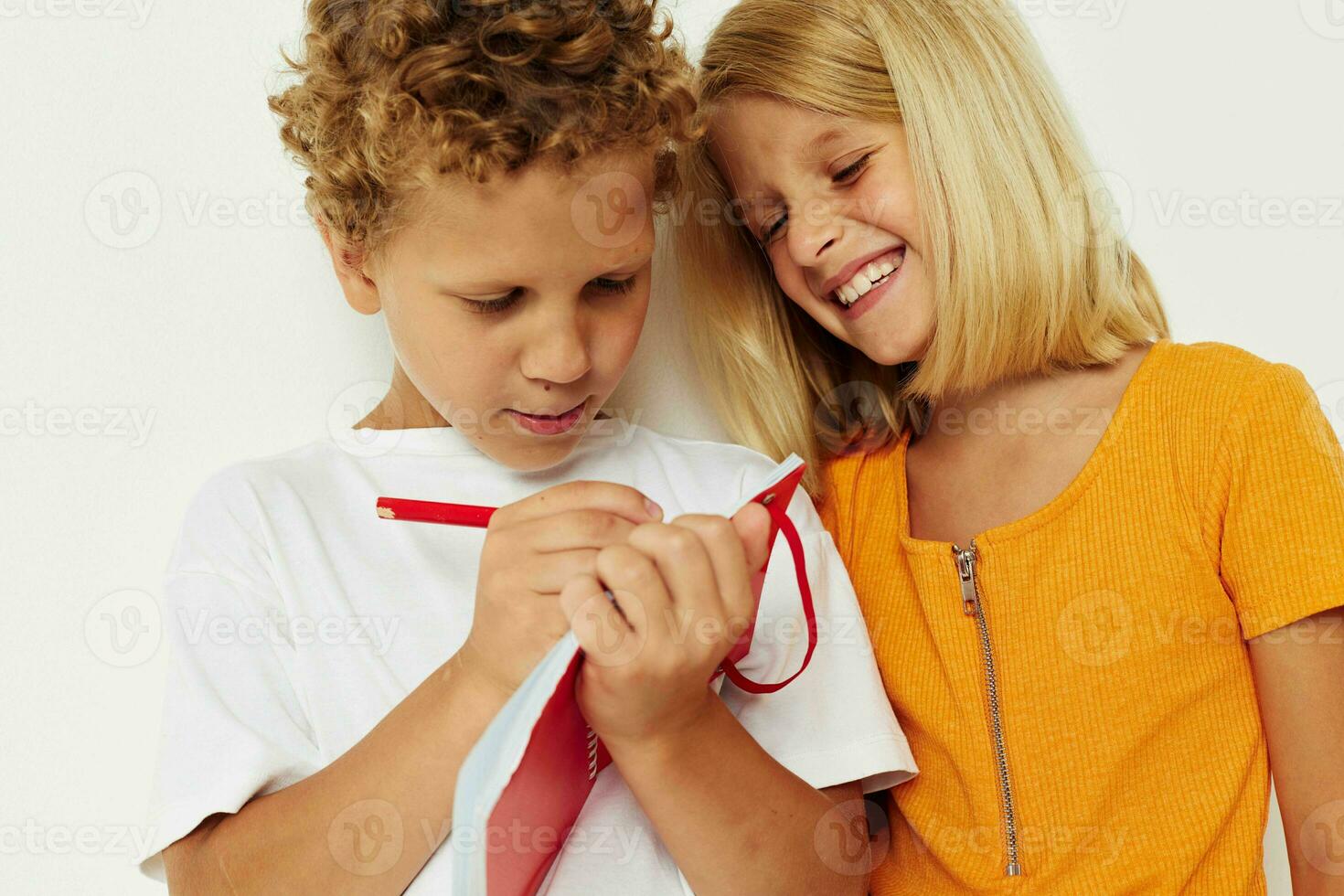 Portrait of cute children fun in colorful t-shirts with a notepad isolated background unaltered photo