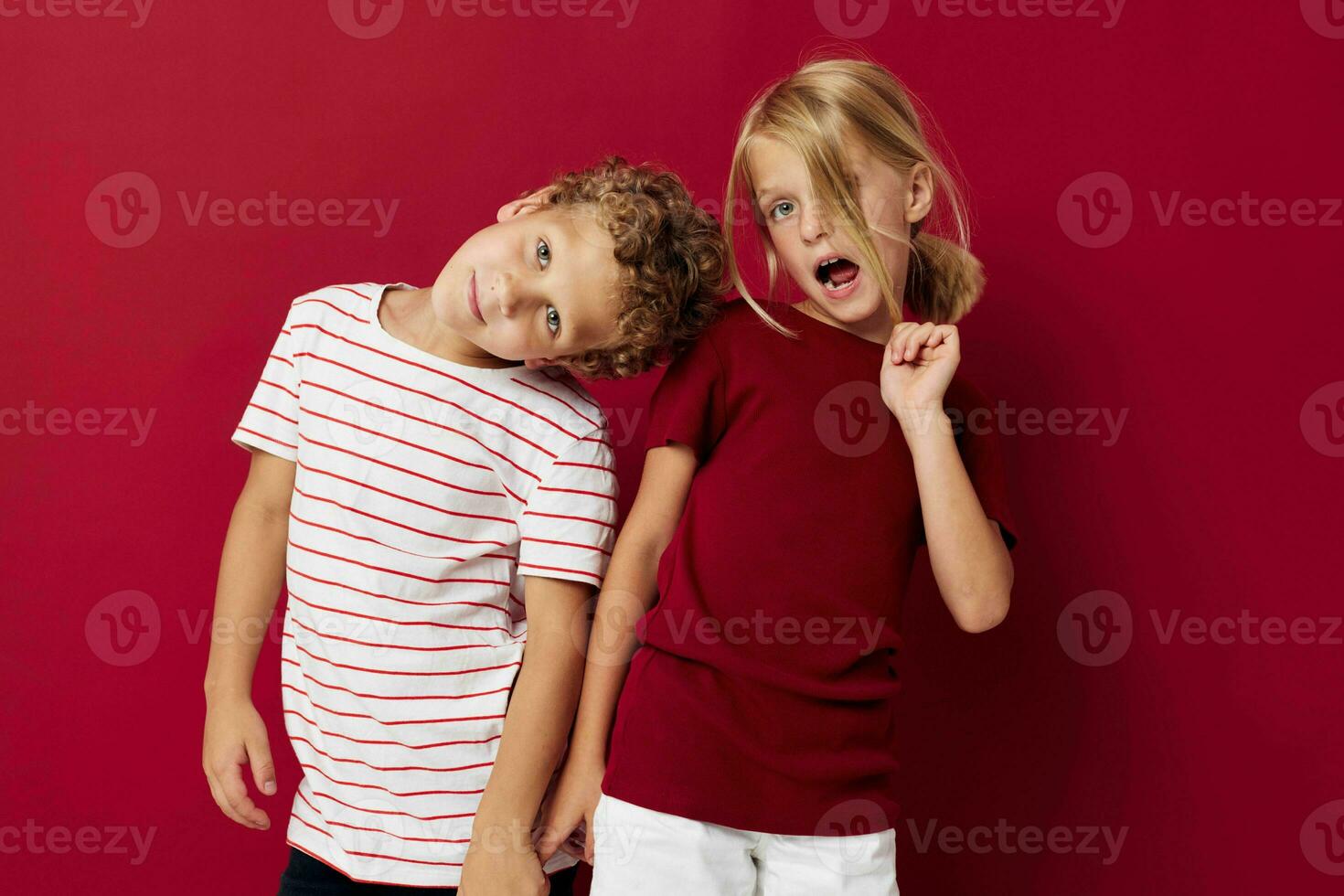 Boy and girl emotions stand side by side in everyday clothes on colored background unaltered photo