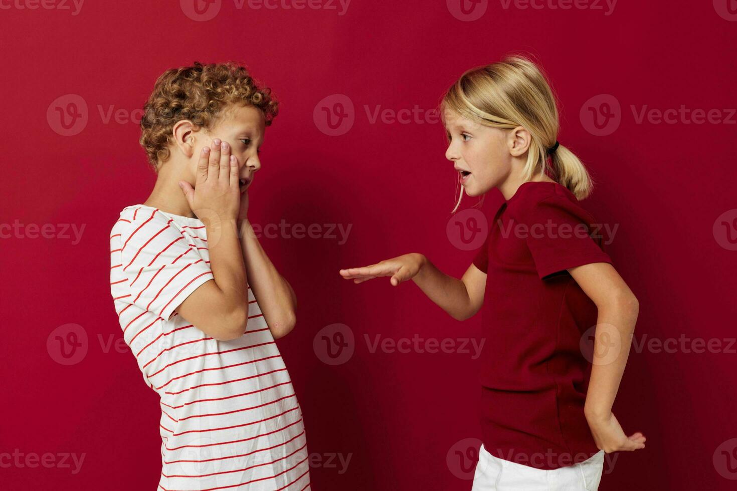 two joyful children emotions stand side by side in everyday clothes isolated background photo