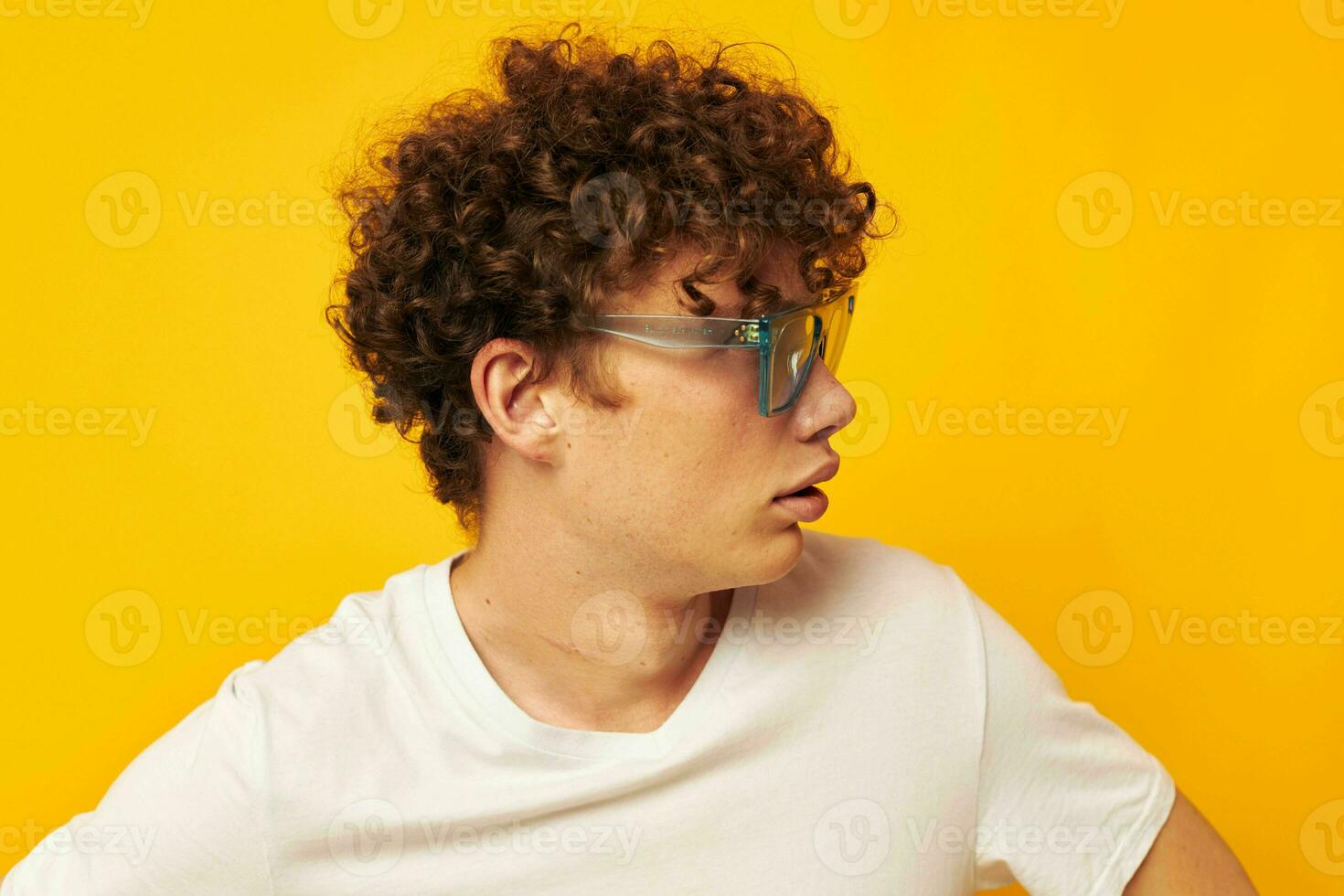 cute red-haired guy in blue glasses white t-shirt fashion modern style yellow background unaltered photo