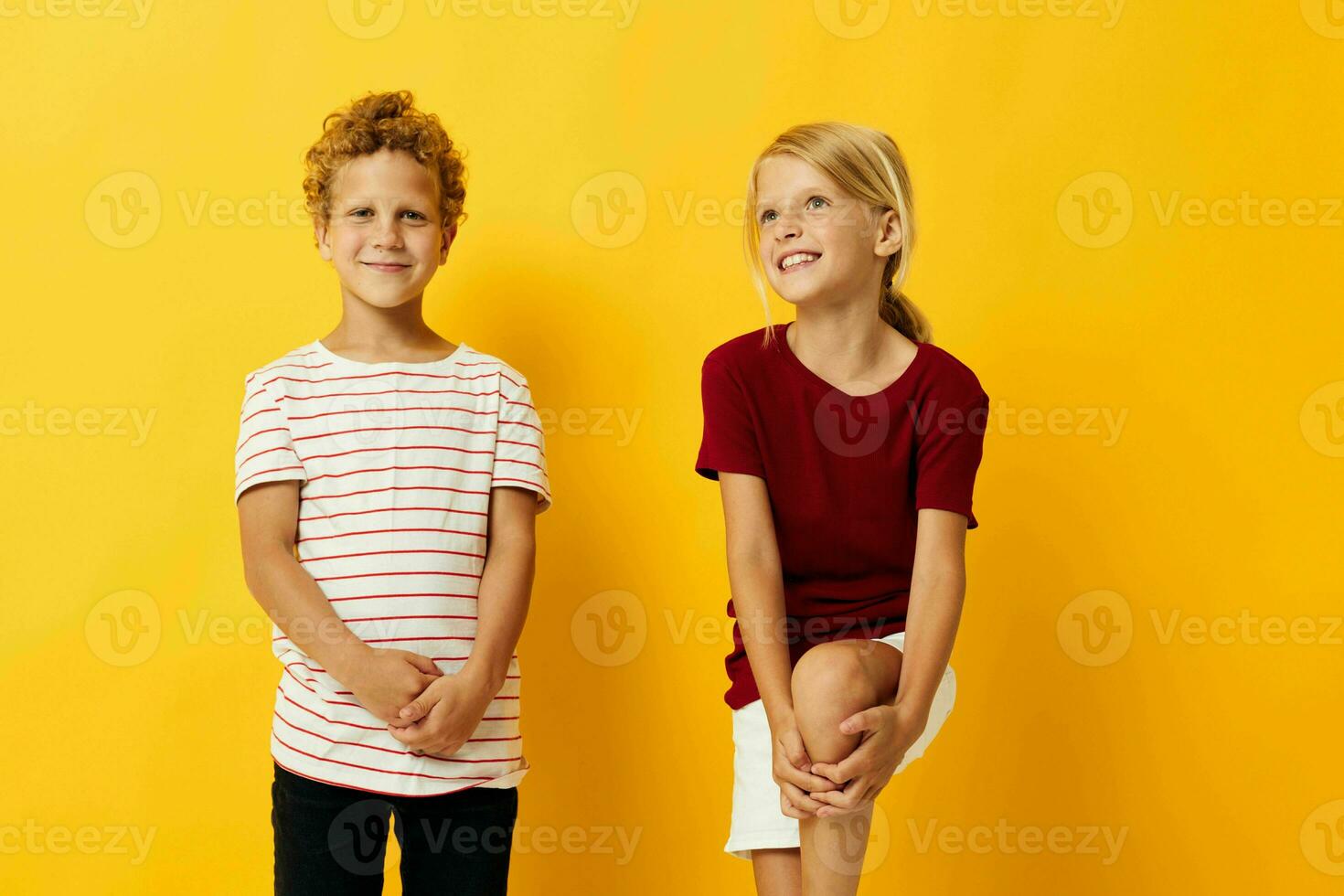 Boy and girl casual wear games fun together yellow background photo