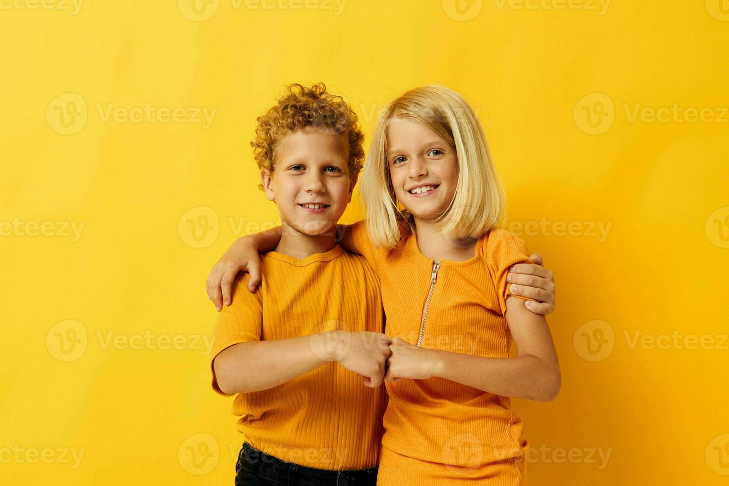 Portrait of cute children cuddling fashion childhood entertainment on colored background photo