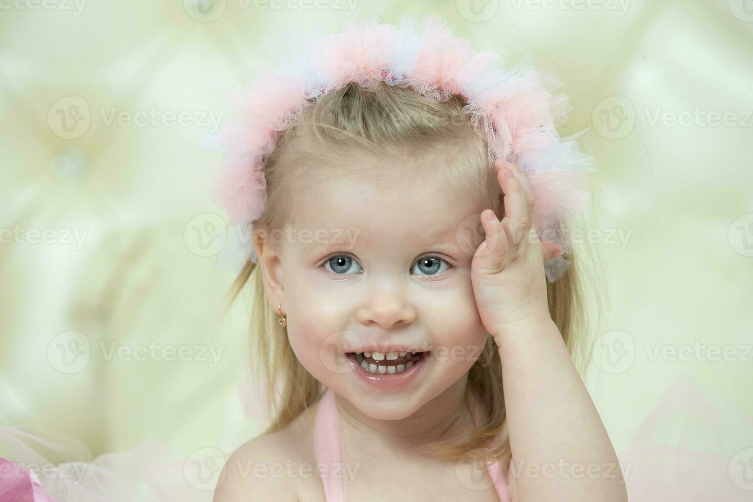 Portrait of a little cheerful girl with pink bows. Two-year-old child. photo