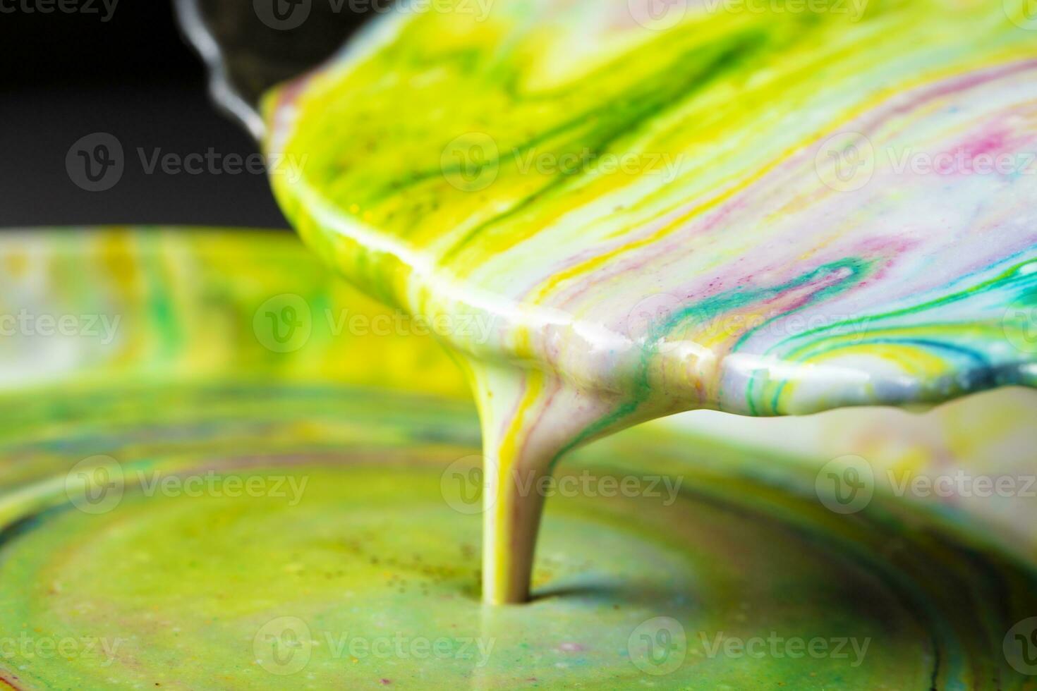 Acrylic paint pours from the plate. Creativity process. photo