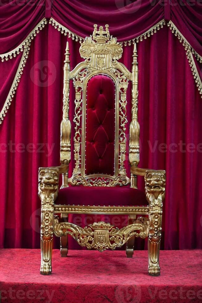 Red royal chair on a background of red curtains. Place for the king. Throne photo